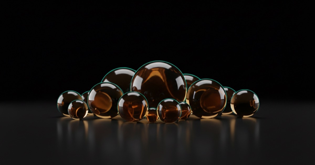 Cholesterol: translucent amber glass spheres of different sizes on a dark surface