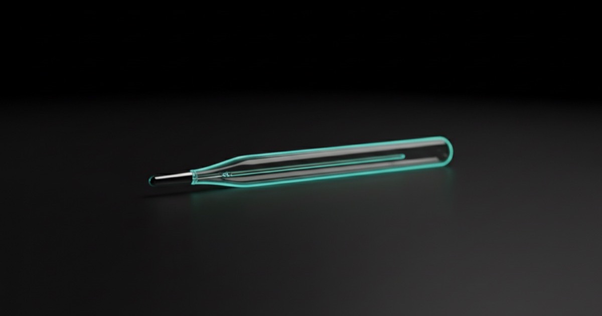 Flu, COVID: clear glass thermometer lying on a dark surface